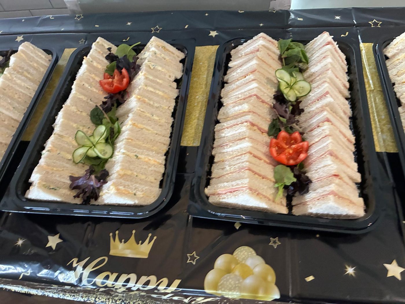 Platters of freshly made sandwiches garnished with salad, cucumber and tomato