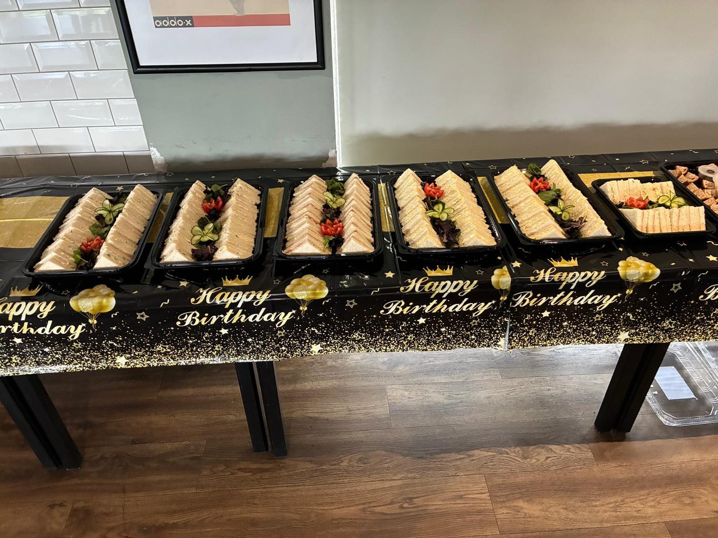 A birthday buffet laid out along a table, tray after tray of sandwiches and savouries